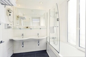 Un bagno moderno con box doccia in vetro, un ampio specchio e un mobile doppio lavabo.