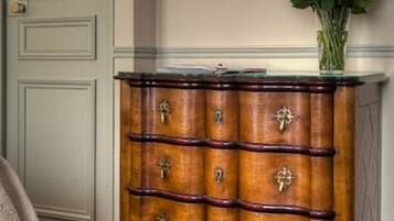 A wooden dresser with multiple drawers, a mirror above it, and a vase with yellow flowers on top.