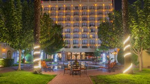 A hotel courtyard at night with a central fountain, seating area, and a building with illuminated balconies. - Hotel Lucerna Ciudad Juarez (Ciudad Juárez)