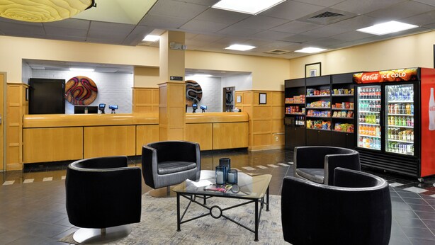 A lobby with a reception desk, seating area, and vending machines. - Hawthorne Inn and Conference Center (Winston-Salem)