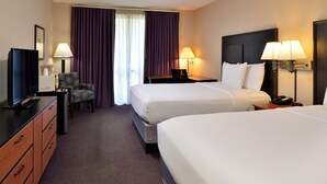 A hotel room with two beds, a desk, a chair, a television, and two lamps. - Hawthorne Inn and Conference Center (Winston-Salem)