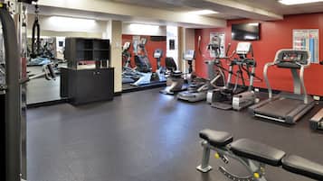 Une salle de sport équipée de machines de cardio, de matériel de musculation et dotée d’un mur avec des miroirs.