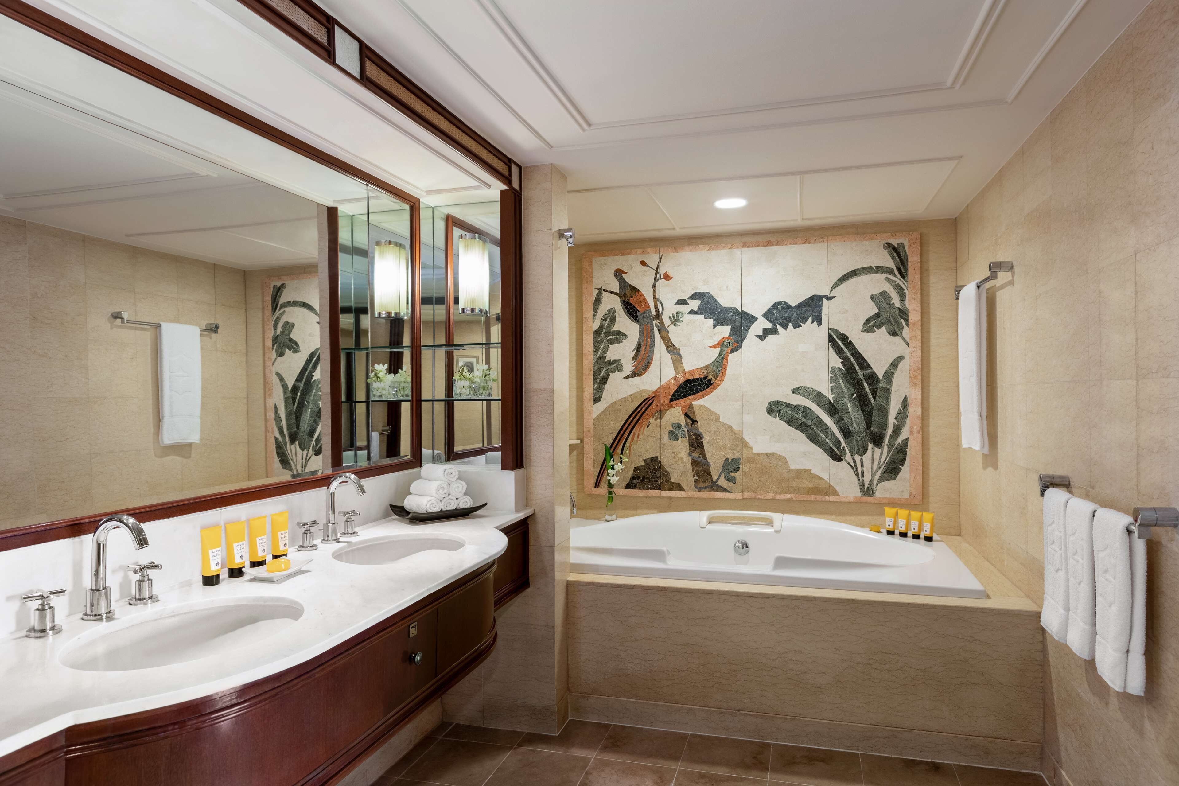 A bathroom with two sinks, a bathtub, and a large mirror.