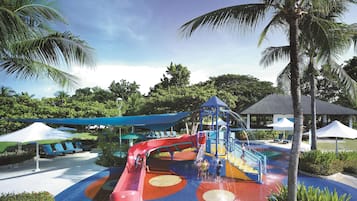 Enjoy a fun-filled day at this vibrant water park with play structures, lounge chairs, and lush surroundings.