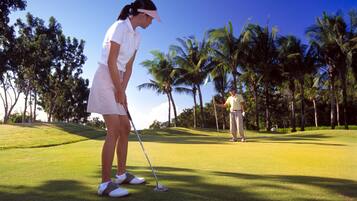 Golfers can enjoy a serene round on this well-maintained course surrounded by lush greenery and palm trees.