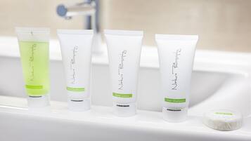 Four tubes of hair care products on a white sink.