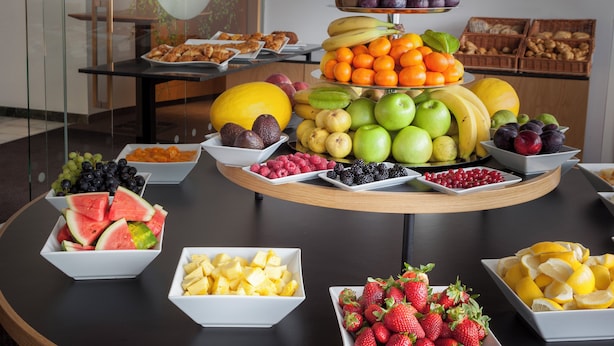 Een presentatie van fruit en groenten, met verschillende soorten fruit en groenten gerangschikt in schalen en op een etagère.