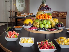 A fruit and vegetable display with various fruits and vegetables arranged in bowls and on a tiered stand. - Hotel Golf Prague (Prague)