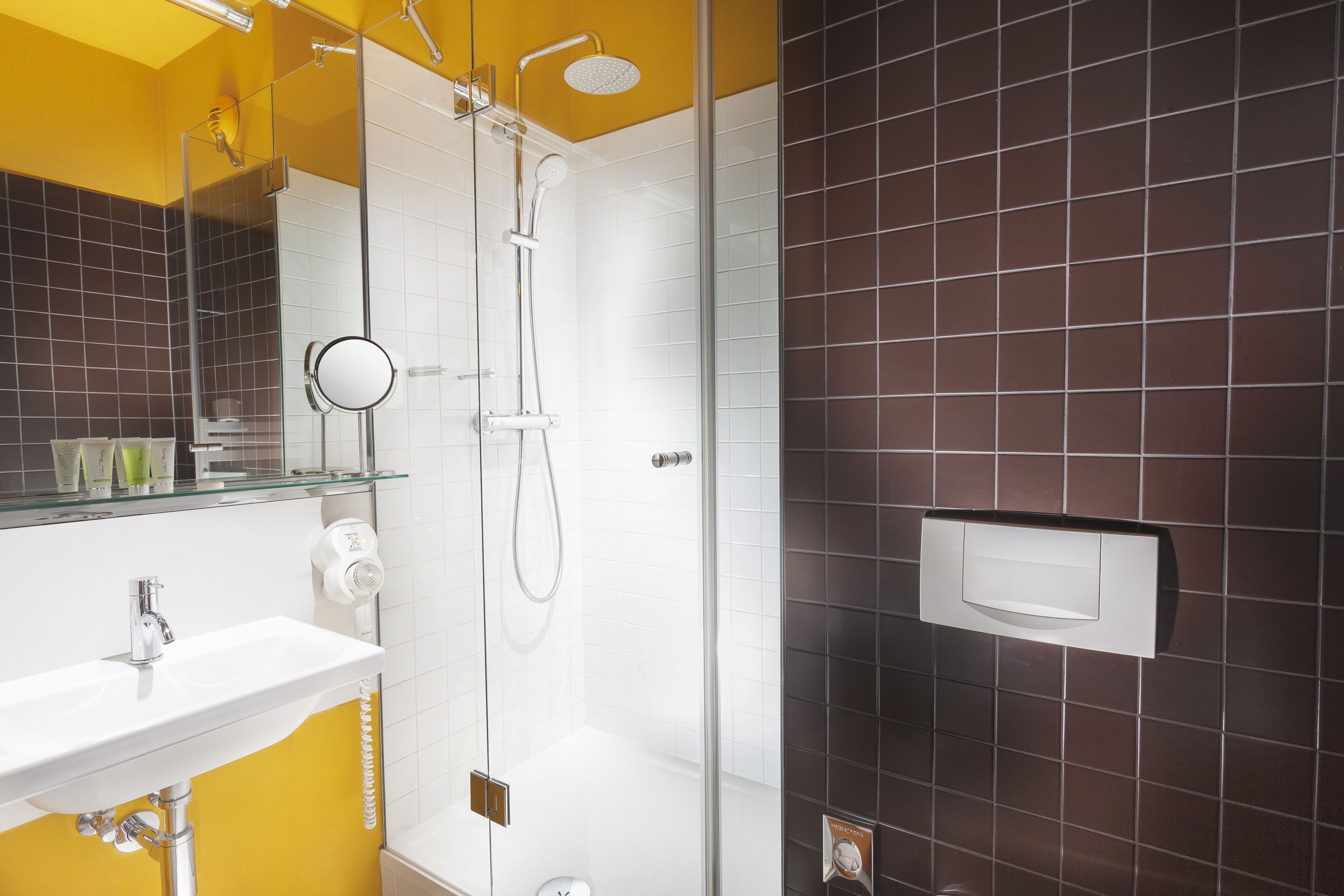 A modern bathroom with a glass shower enclosure, a white sink, and a mirror above it.