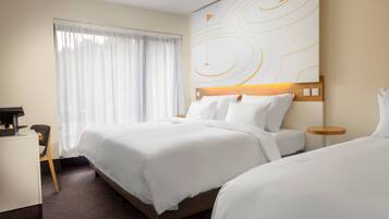 Habitación de hotel con una cama, un escritorio y una silla.
