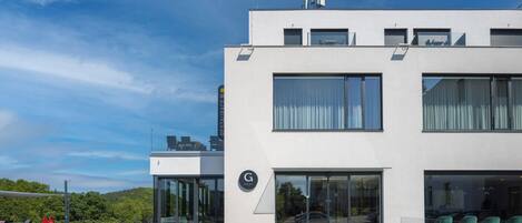 Un hotel moderno con techo plano, ventanas amplias y una entrada destacada.