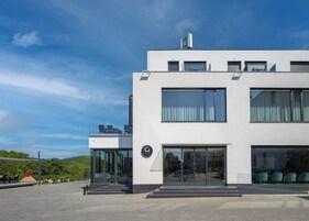 Un hotel moderno con tetto piatto, ampie finestre e un ingresso ben visibile.