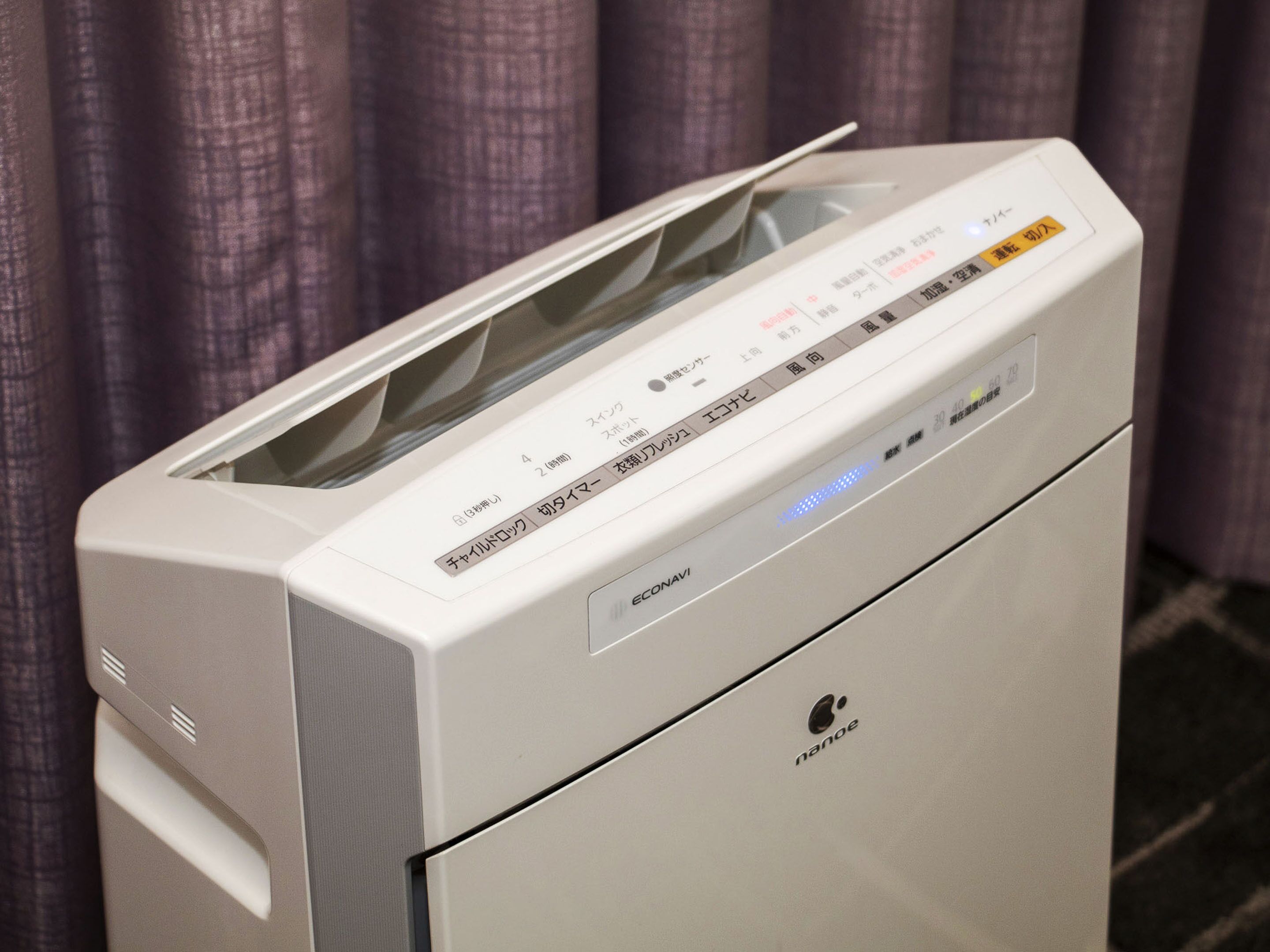 A white electronic device with a control panel, possibly a printer or scanner, with Japanese text and a brand name 'nanoe' visible.