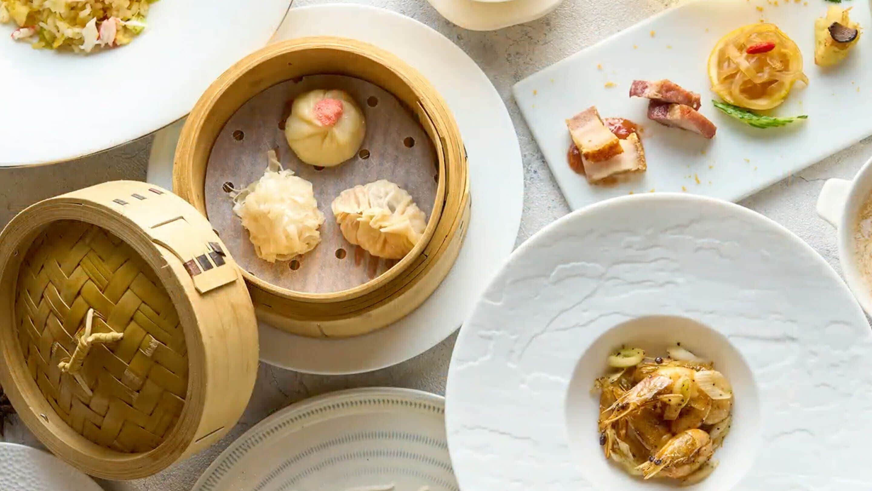 A variety of dishes including dumplings, sashimi, and a plate with a seafood dish.