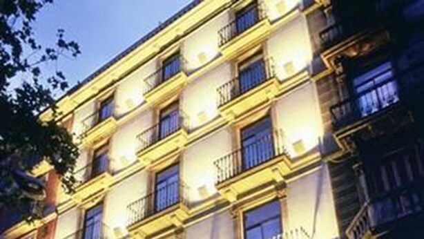 A multi-story hotel with balconies and a sign indicating it is a hotel.
