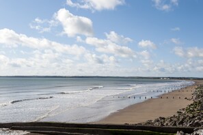 A beach with a stone wall and a clear sky.