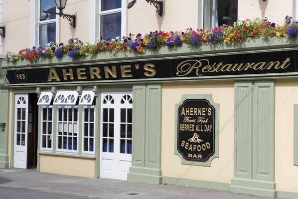 A restaurant named "Aherne's Restaurant" with a sign stating "Aherne's Finest Food Served All Day Seafood Bar".