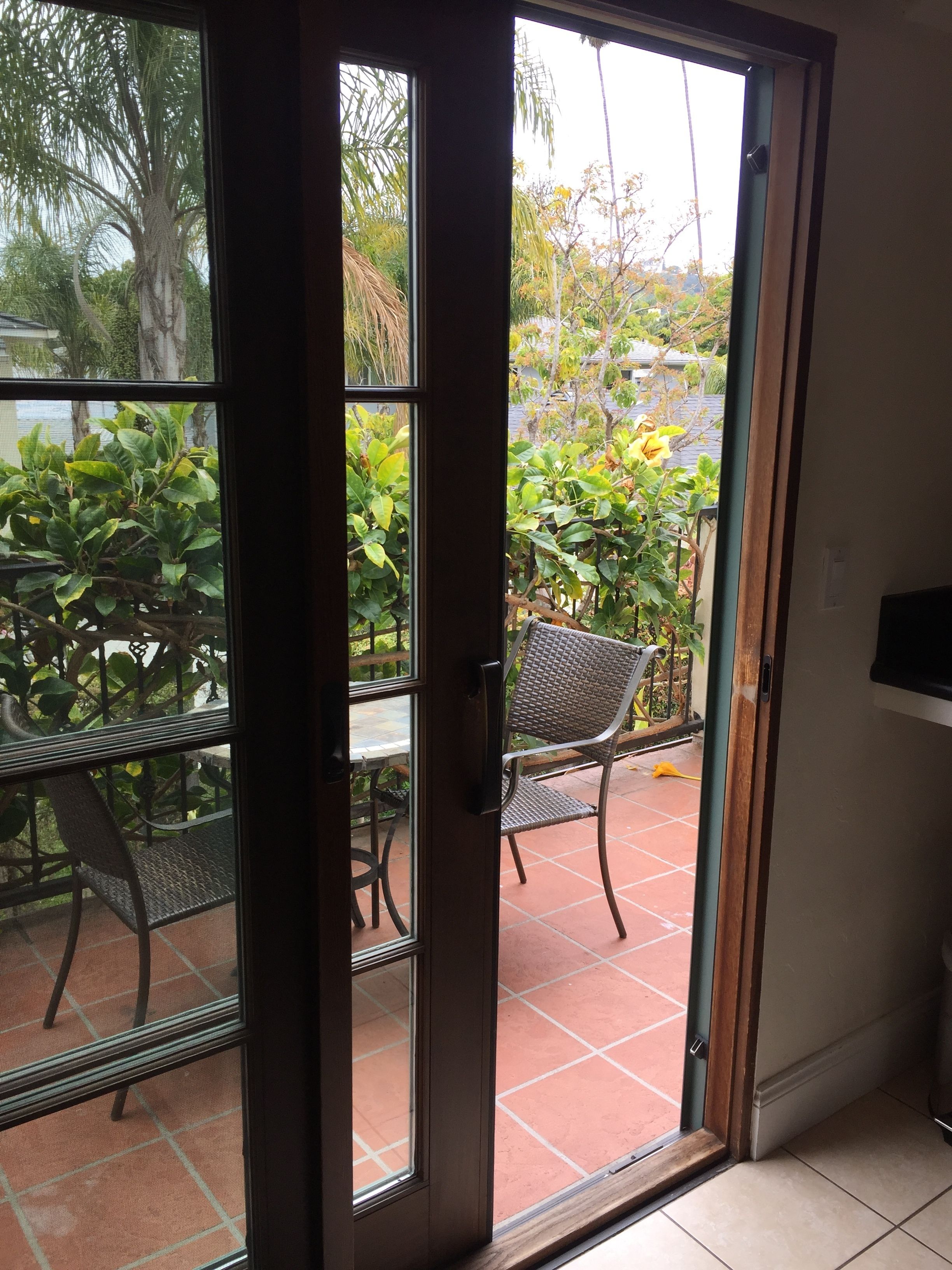 A sliding glass door leading to an outdoor patio with a table and chairs.