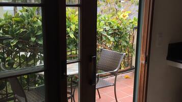 A sliding glass door leading to an outdoor patio with a table and chairs.