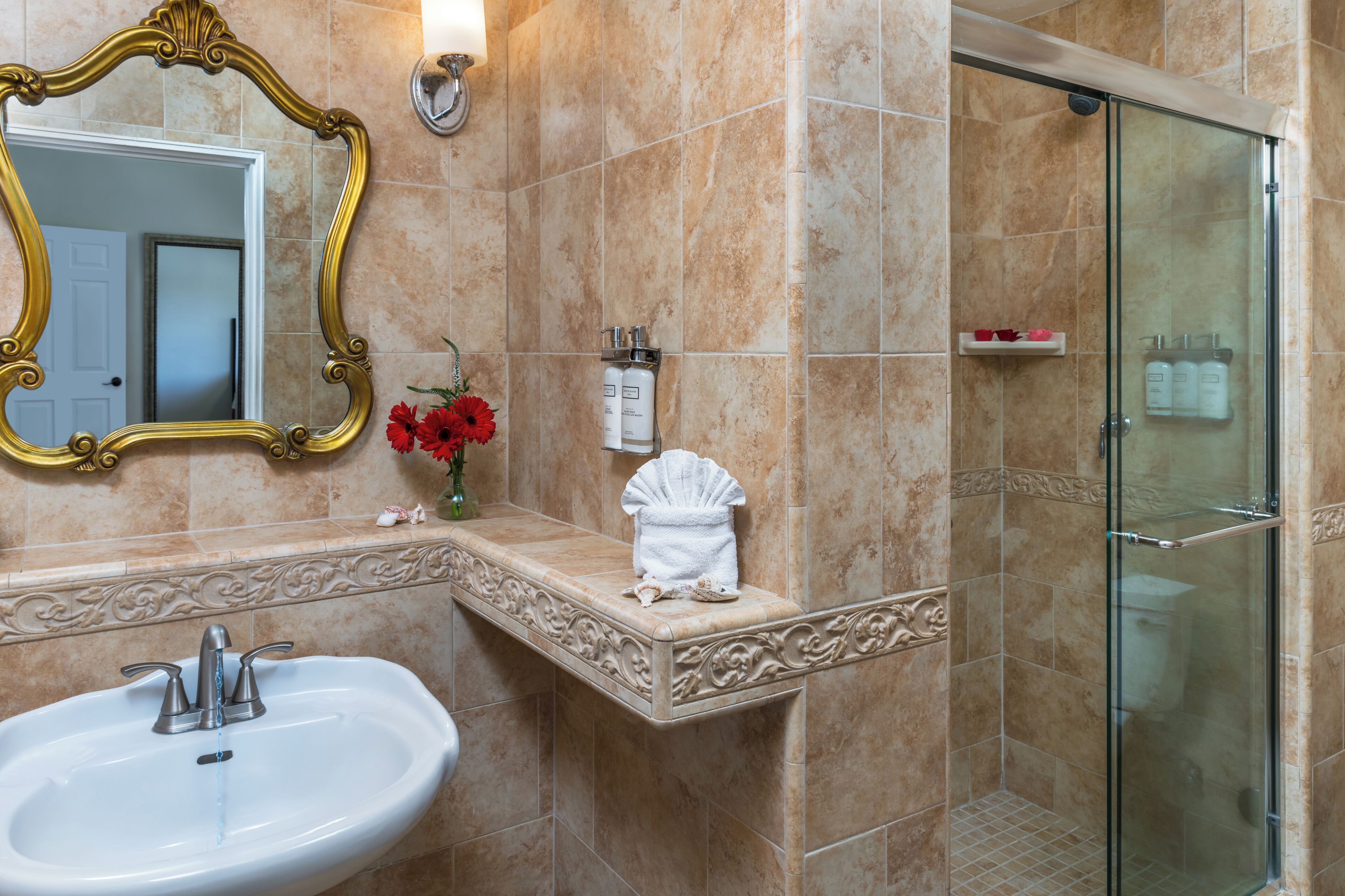 Baño con lavamanos, espejo y ducha.