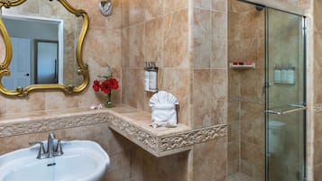 Baño con lavamanos, espejo y ducha.