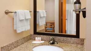 Ein Badezimmer mit Waschbecken, Handtuchhalter und Spiegel.