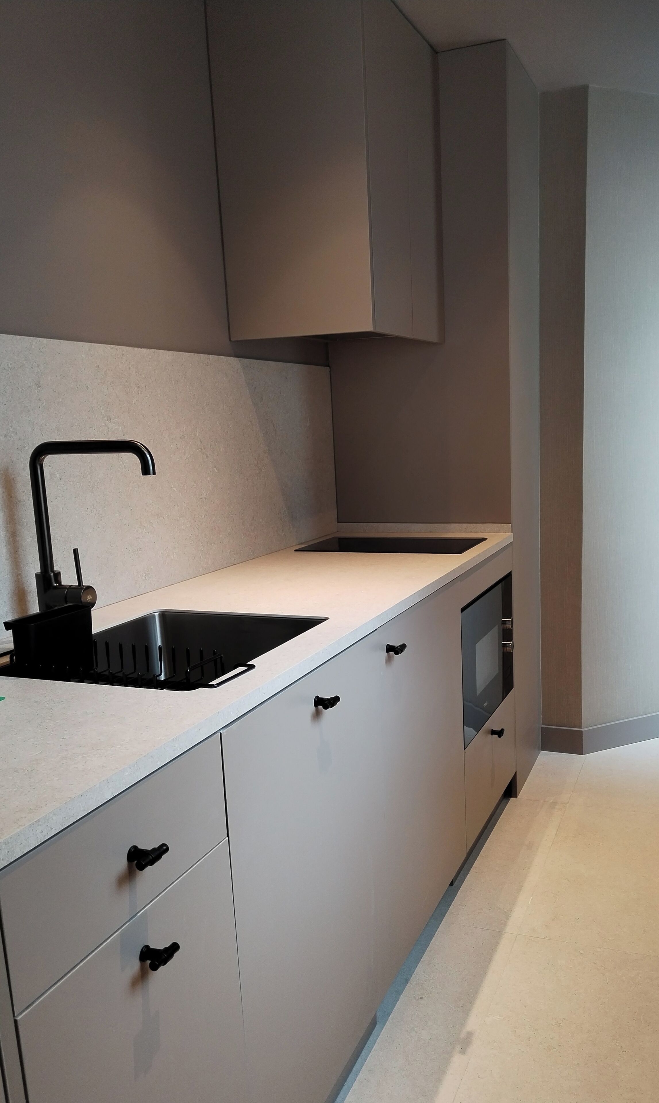 Una cuina moderna amb un taulell elegant, una barra d'obra integrada i un forn encastrat.
