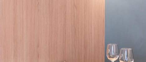 Een eetgedeelte met een ronde tafel, twee stoelen en een wandlamp.