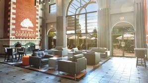 A spacious lobby with a fireplace, multiple seating areas, and large windows offering views of the outdoors.