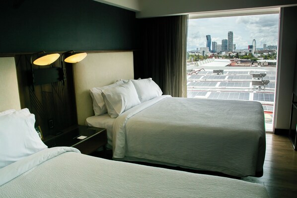 A hotel room with two beds, a city view, and a large window. - Courtyard by Marriott Puebla Las Animas (Puebla)