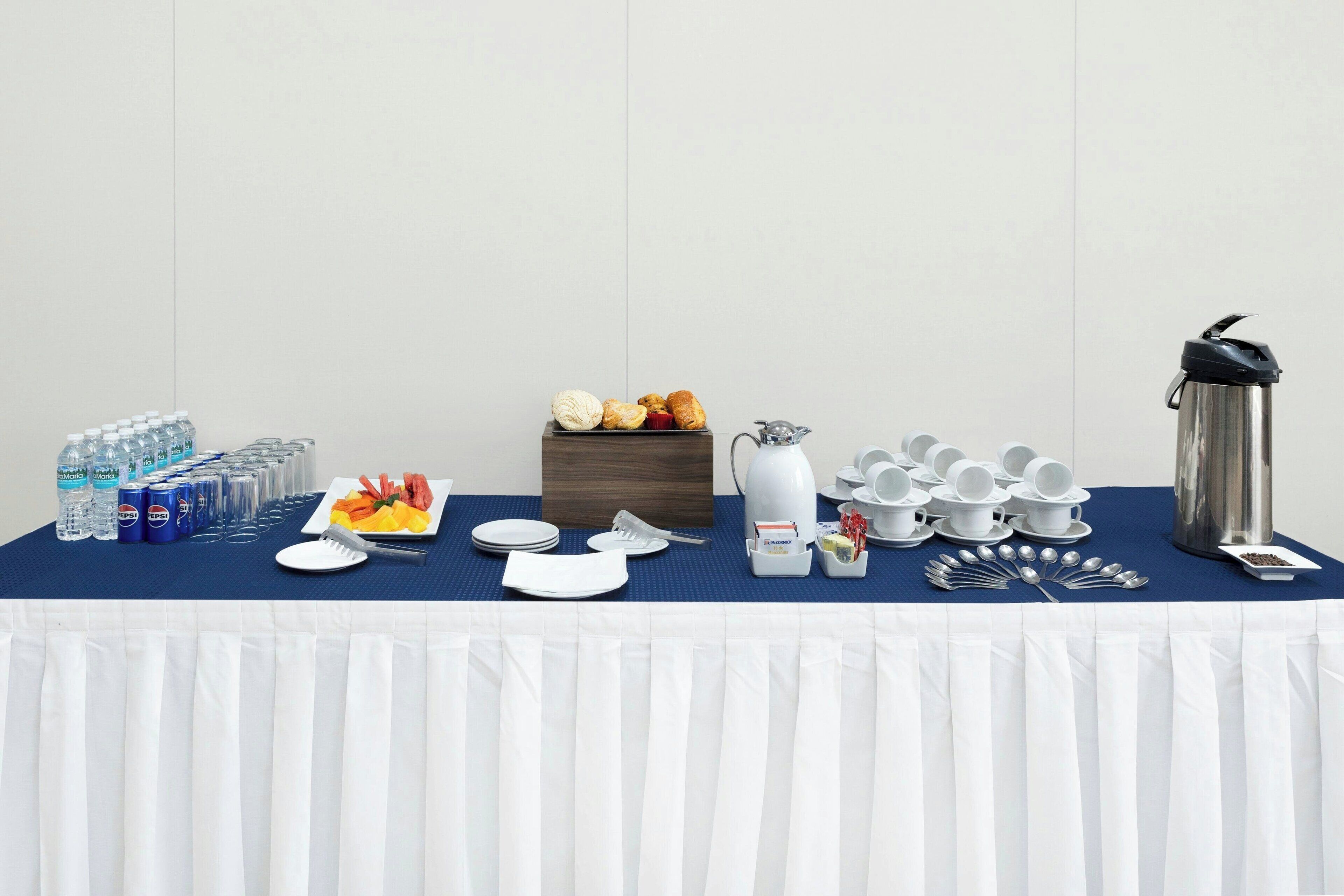 Ein reichhaltiges Frühstücksbuffet mit verschiedenen Speisen, Getränken und Besteck auf einer Tafel.