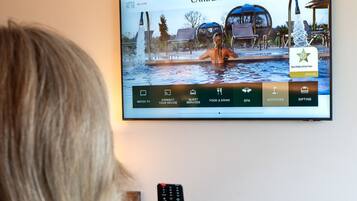 A television screen displaying a spa hotel named 'Carden Park' with a pool area, a guest services menu, and a 'Spa Hotel of the Year' award for 2024/25.
