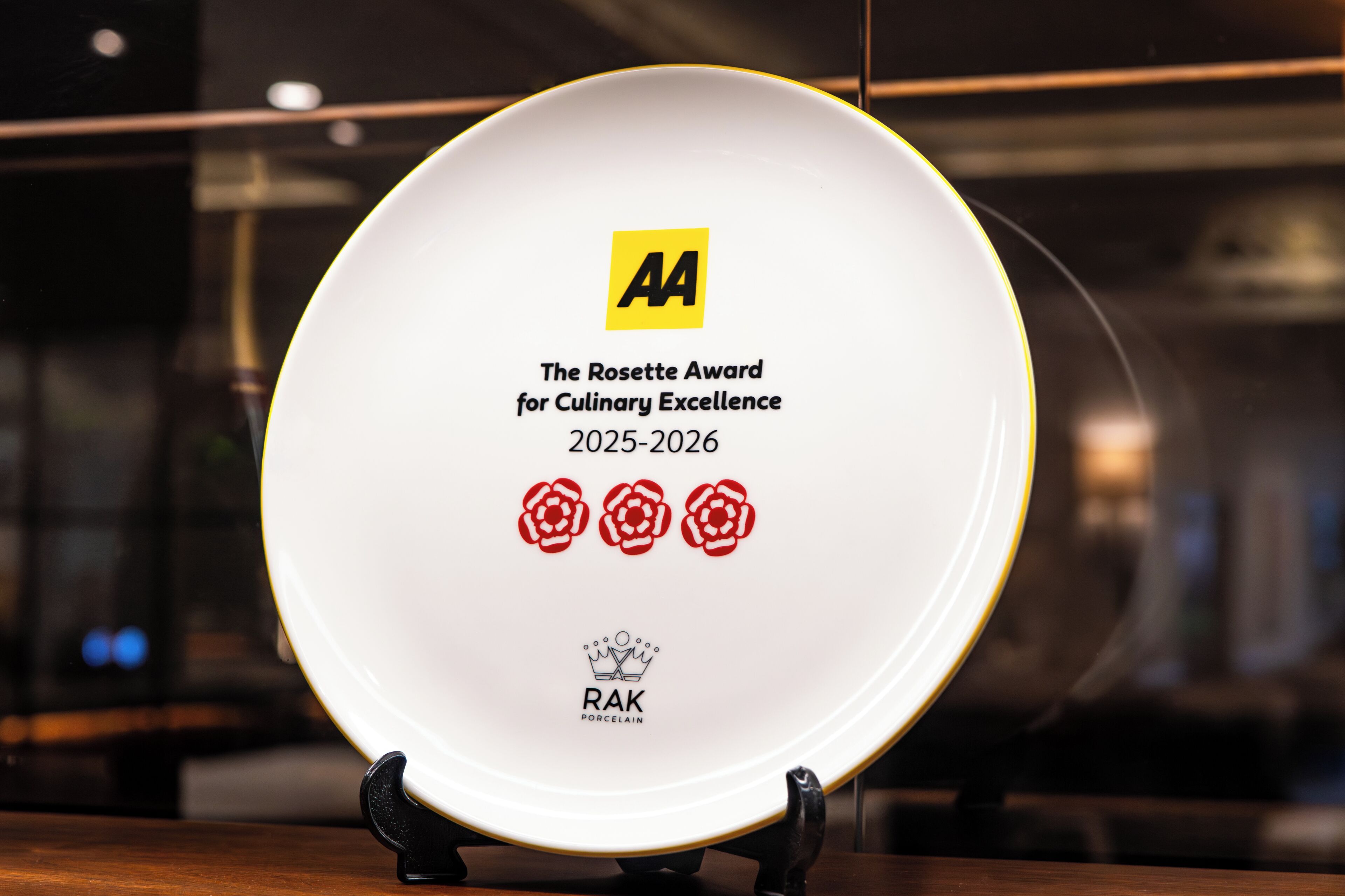 Un plato con la inscripción 'The Rosette Award for Culinary Excellence 2025-2026' y 'RAK PORCELAIN'.
