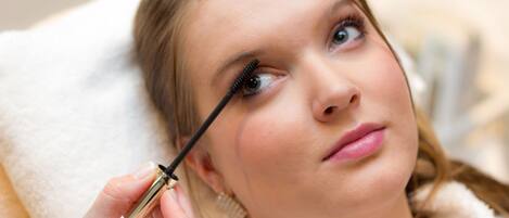 A person holding a mascara tube.