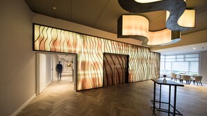 A modern interior with a wooden herringbone floor, a unique wall design, and a contemporary table. - Bilderberg Résidence Groot Heideborgh (Garderen)