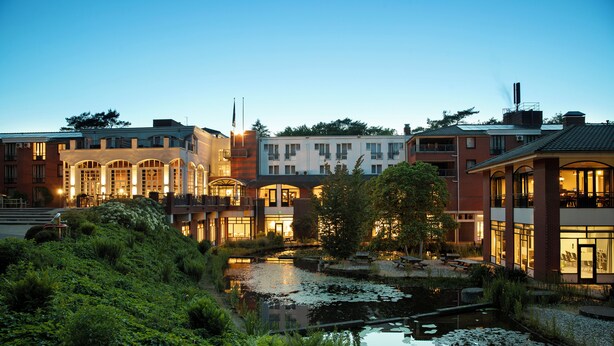 A hotel with a pond, surrounded by lush greenery and modern architecture. - Bilderberg Résidence Groot Heideborgh (Garderen)