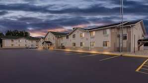 A hotel with multiple buildings, a parking lot, and a clear sky.