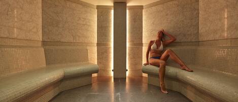 A spa room with two seating areas and a central light fixture.