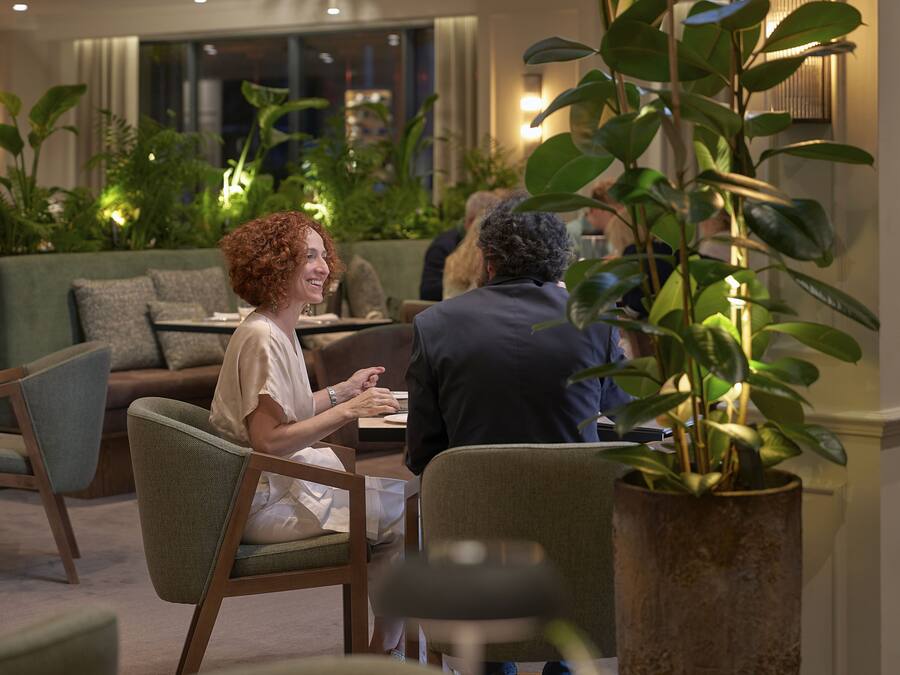 A cozy indoor setting with seating arrangements and potted plants.