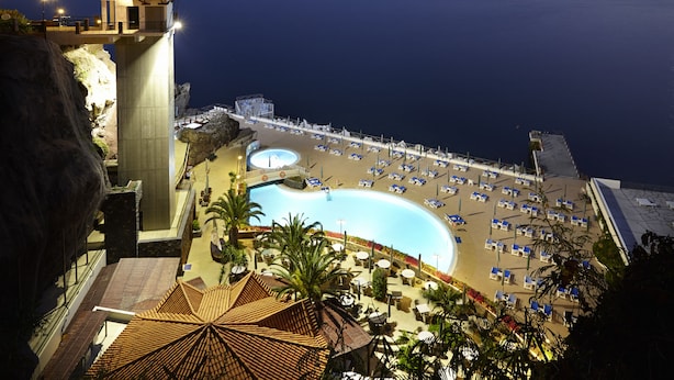A resort with a large pool, beach area, and a high vantage point overlooking the sea.