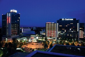 A cityscape at dusk with prominent buildings including the DORUMERO HOTEL and SI-Centrum.