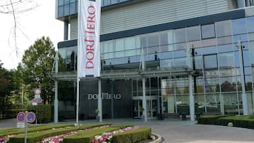Un edificio moderno con fachada de vidrio y una bandera que dice "DORITERO".