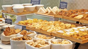 Mostrador de panadería con una variedad de productos horneados, como pan, pasteles y sándwiches.