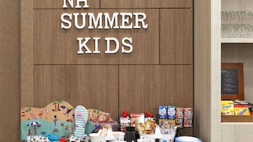 A display for NH Summer Kids with various food items and a beach-themed backdrop.