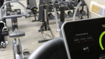 Panel de control de equipo de gimnasio con ajustes de programa y pantalla digital.