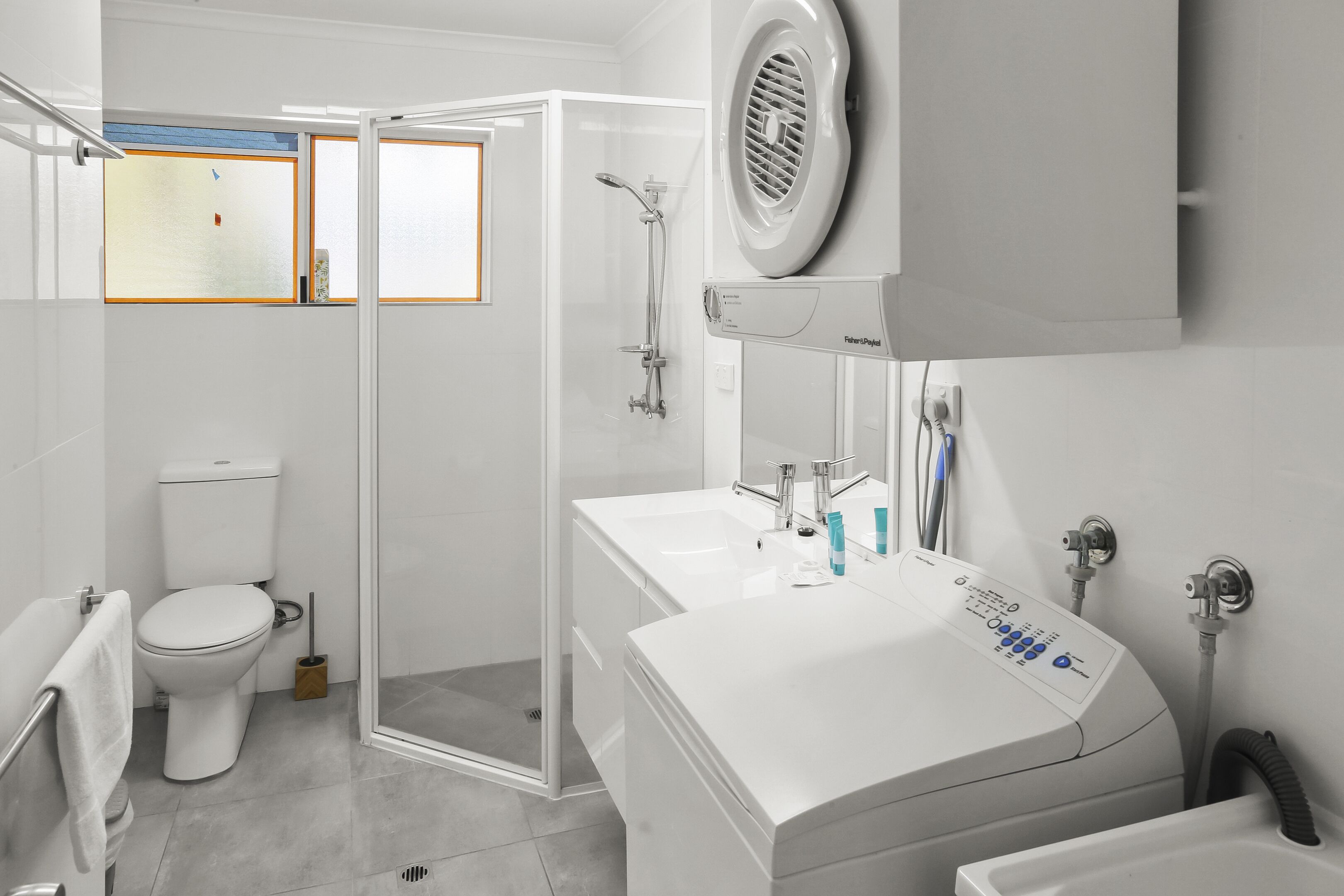 Une salle de bain moderne équipée de toilettes, d’une douche et d’un lavabo.
