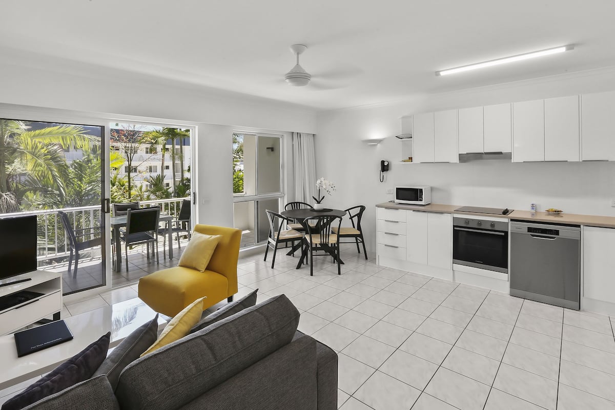 Un apartamento moderno con balcón, comedor, cocina y sala de estar.