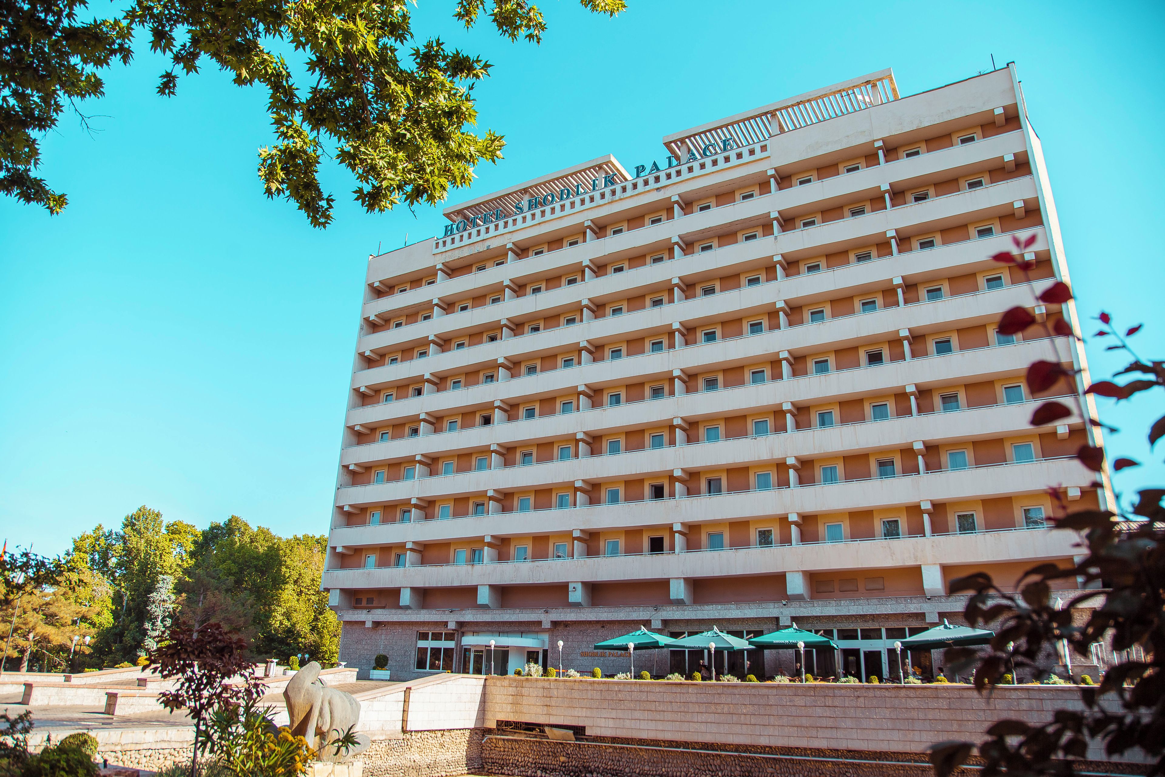 Un hôtel à plusieurs étages, doté d’une façade uniforme, de balcons et surplombant un ciel dégagé.
