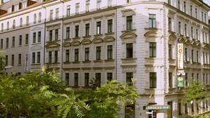 Un edificio histórico de hotel con varios pisos, ventanas grandes y un estilo arquitectónico clásico.