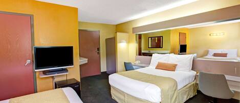 A hotel room with a large bed, a television, a desk, and a chair.